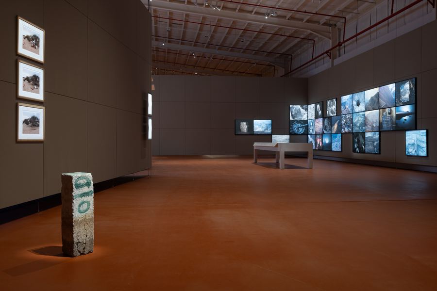 Installation view, inscribed concrete pillar and archival photo wall, JAX District